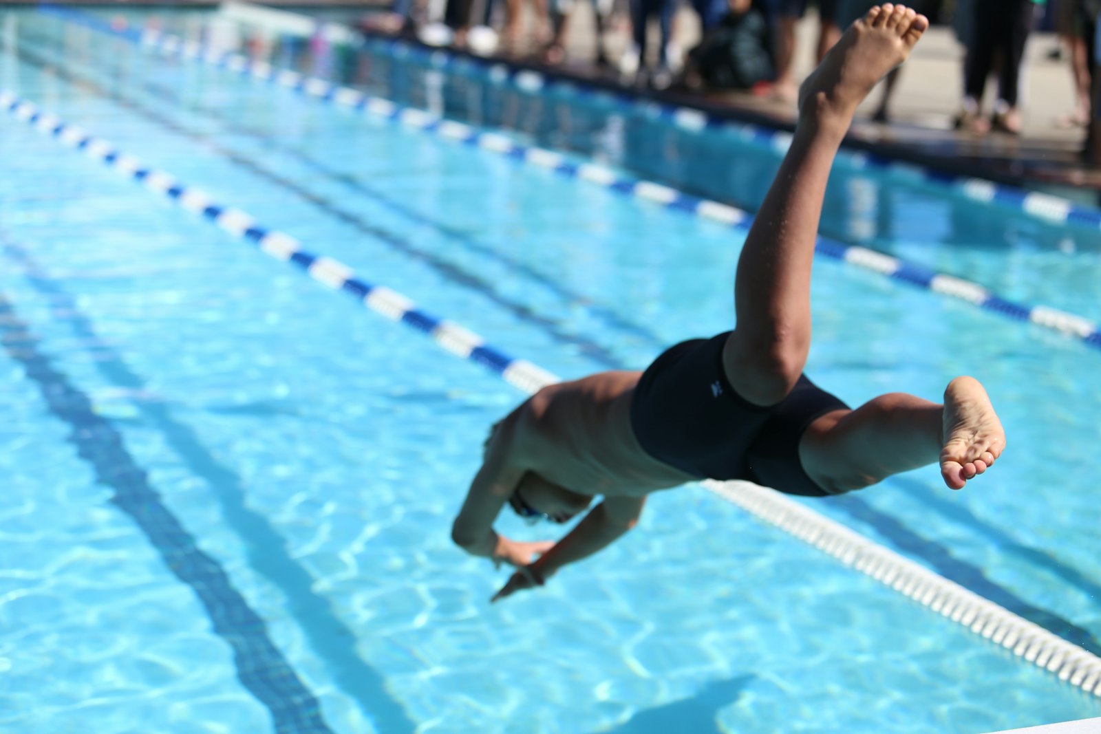 Young swimmer diving into the pool at a gala